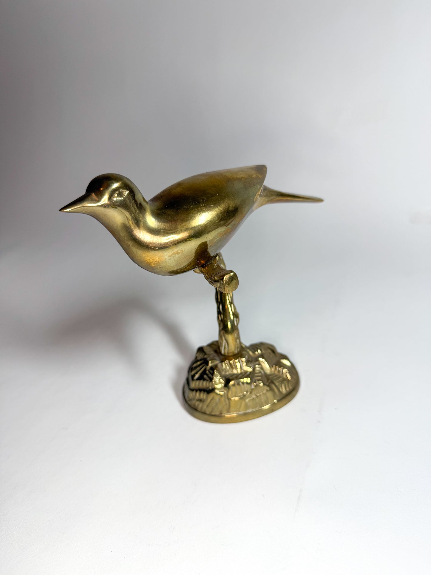 Brass bird on branch