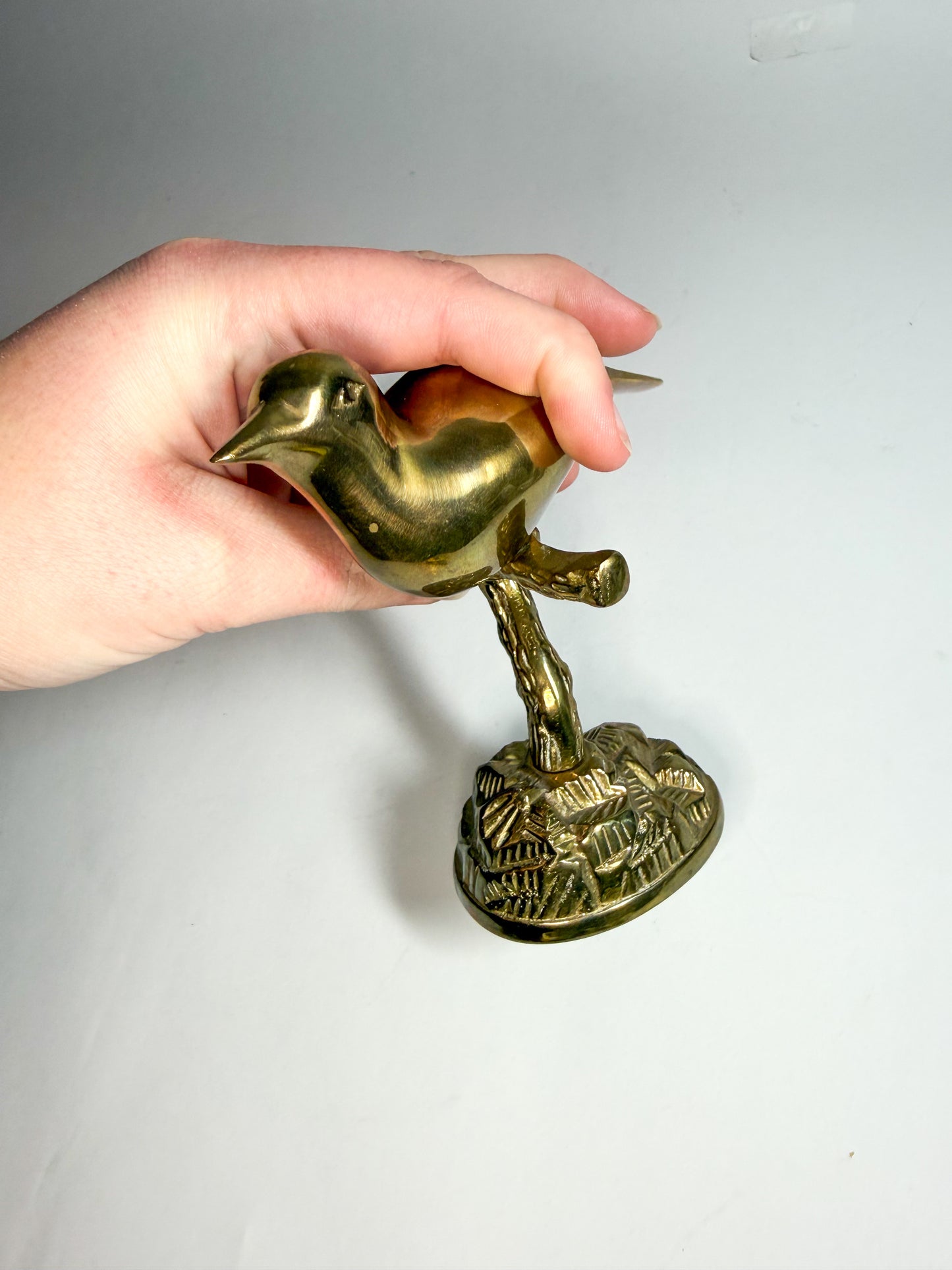 Brass bird on branch