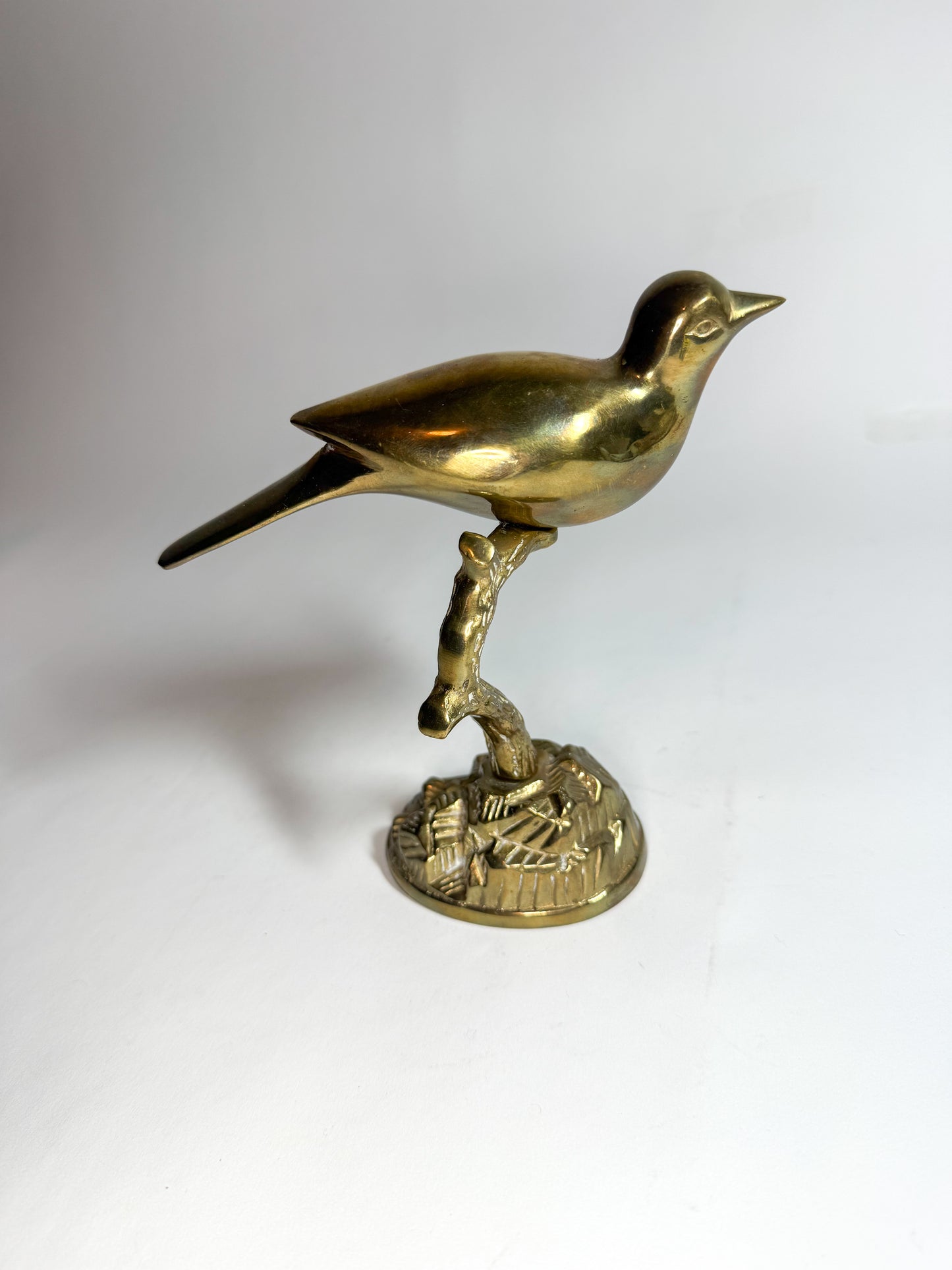 Brass bird on branch